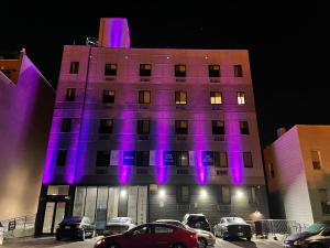 布魯克林的住宿－King Hotel Brooklyn Sunset Park，建筑的侧面有紫色的灯