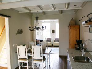 a kitchen with a dining table and white chairs at Holiday home near Wadden Sea in Paesens