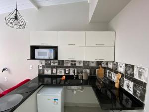 cocina con armarios blancos y encimera en Waikiki Apartament Ipanema, en Río de Janeiro