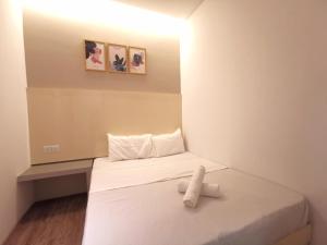 una piccola camera con un letto e un asciugamano sopra di Maco Inn Austin Heights @Johor Bahru a Johor Bahru
