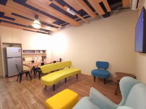 新山的住宿－Maco Inn Austin Heights @Johor Bahru，客厅配有黄色和蓝色的椅子和桌子