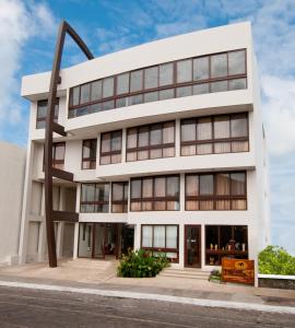 a large white building with a pole in front of it at Hotel Isla Sol by Solymar in Puerto Ayora