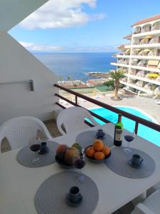 una mesa con copas de fruta y vino en el balcón en Paraiso Canario, en Puerto de Santiago