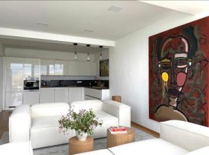 uma sala de estar com mobiliário branco e uma pintura na parede em Modernes Apartment mit wunderschonem Rheinblick em Urmitz