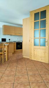 a kitchen with a wooden door and a table at CASA EMMA in Mezzana