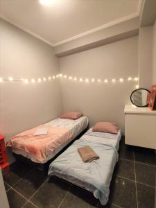 - 2 lits dans une chambre avec un miroir et des lumières dans l'établissement Hospedaria Studio 373 - Vila Mariana - Valores Acessíveis, à São Paulo