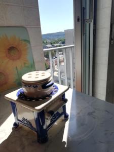 - une table avec un bol sur le balcon dans l'établissement Nino e Issi Apartment, à Trieste