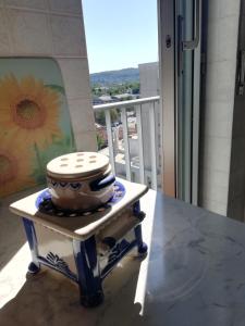 un tavolo con una ciotola in cima a un balcone di Nino e Issi Apartment a Trieste