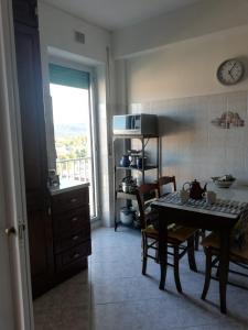 kuchnia ze stołem, krzesłami i kuchenką mikrofalową w obiekcie Nino e Issi Apartment w Trieście