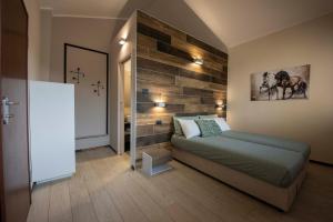 sypialnia z łóżkiem i drewnianą ścianą w obiekcie Agriturismo Cascina Costa w mieście Cassago Brianza