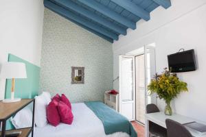 a bedroom with a bed with pink pillows on it at Alojarte Mezquita 5 in Seville