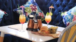 a table with two drinks and a sandwich and drinks at Empire Guesthouse in Leribe