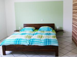 een bed met blauwe en gele dekens en kussens bij Ferienwohnung Knobloch in Wahlheim