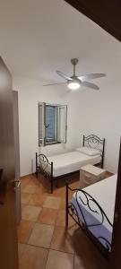 a room with two beds and a ceiling fan at Wild Cilento in Castellabate