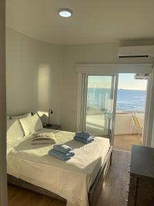 a bedroom with a bed with a view of the ocean at Alex Beach Apartment 34 in Larnaca