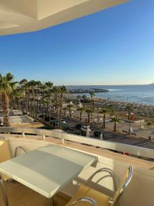 a table and chairs on a balcony with a view of the beach at Alex Beach Apartment 34 in Larnaca