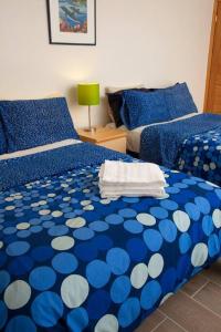 um quarto com 2 camas com lençóis azuis e brancos em Beautiful Ocean views at Quinta la Mexicana! 8 ppl em Ensenada