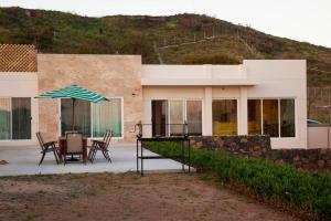 una casa con mesa, sillas y sombrilla en Beautiful Ocean views at Quinta la Mexicana! 8 ppl, en Ensenada