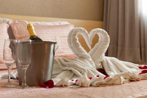 a table with two swans towels and a bottle of champagne at Hotel Olympia in Vila Velha