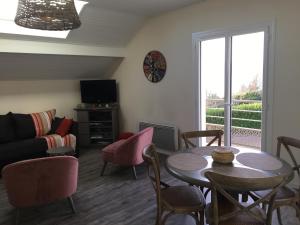 a living room with a table and chairs and a couch at Les Gîtes du Lachat in Saint-Sylvestre