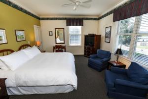 a bedroom with a white bed and a blue chair at Oakmont Inn in Verona