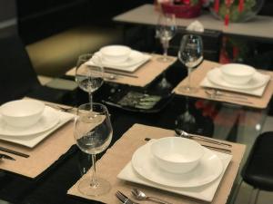 a table with plates and wine glasses on it at Lakeside Home in Ipoh
