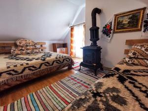 - une chambre avec un lit et un poêle à bois dans l'établissement Căbănuța din Pădure, à Borşa
