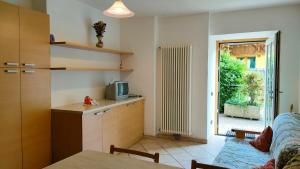 a kitchen with a table and a tv and a window at CASA PICCOLO SOLE in Mezzana