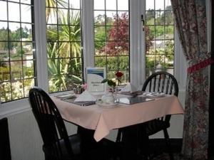 a table with two chairs and a table with a table cloth at Burleigh House in Torquay