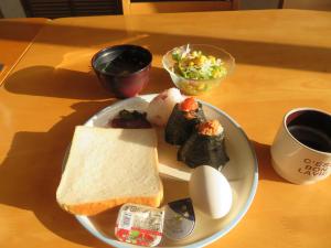 un plato de comida con un sándwich y huevos en una mesa en Hotel Marue - Vacation STAY 76469v en Kamaishi
