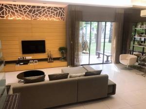 a living room with a couch and a flat screen tv at Lakeside Home in Ipoh