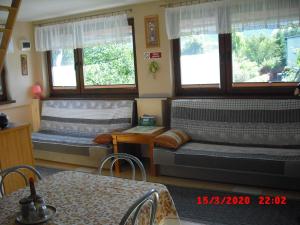 a living room with two beds and a table at Domek HANA in Radków