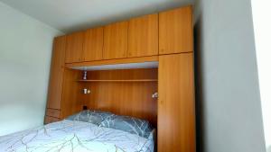 a bedroom with a bed in a wooden cabinet at CASA PICCOLO SOLE in Mezzana
