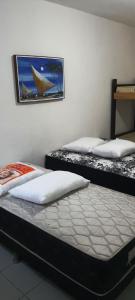 2 camas en una habitación con una foto en la pared en Pousada Savoy, en Fortaleza