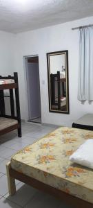 1 dormitorio con cama y espejo en la pared en Pousada Savoy, en Fortaleza