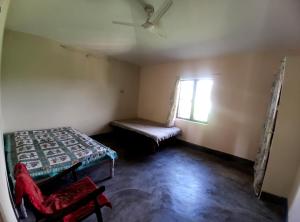 a room with a bed and a window and a chair at Pahaadi House Homestay in Dāngchura