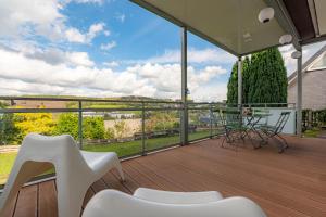 a balcony with white chairs and a view of the city at Architektenwohnungen mit Panoramablick bei Köln in Lindlar