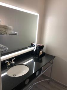 W łazience znajduje się umywalka i lustro. w obiekcie Rodeway Inn w mieście Lake Wales
