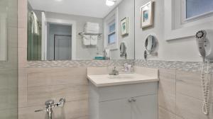 East Hampton House Resort في إيست هامبتون: حمام مع حوض ومرآة