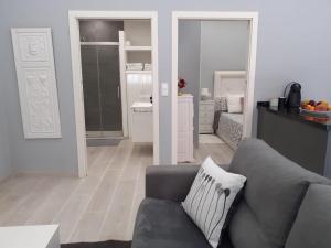 uma sala de estar com um sofá cinzento e um quarto em Apartamento a 50 metros de la playa en Fuengirola em Fuengirola