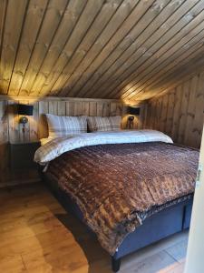 a bed in a room with a wooden ceiling at New cabin at Lifjell perfectly located for hiking with sauna and ski-in/ski-out in Bø