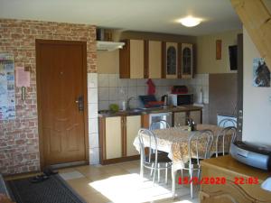 a kitchen with a table and a table and chairs at Domek HANA in Radków