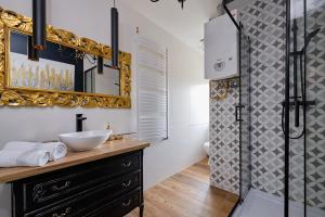 a bathroom with a sink and a mirror and a shower at Art Apartment Szczawno Zdrój in Szczawno-Zdrój