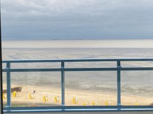 ein Blick aus einem Fenster auf einen Strand mit gelben Objekten in der Unterkunft Silbermöwe - Traumhafter Meerblick in Cuxhaven + 4 Fotos