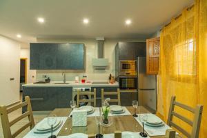 Una cocina con una mesa de madera y un comedor. en CASA ANGEL PAMPANEIRA 3 HAB 2 BAÑOS FACIL ACCESO, en Pampaneira 5 fotos más