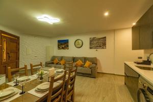 Una cocina y una sala de estar con una mesa y un sofá. en CASA ANGEL PAMPANEIRA 3 HAB 2 BAÑOS FACIL ACCESO, en Pampaneira