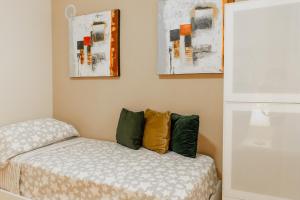 1 dormitorio con 1 cama y algunos cuadros en la pared en Lindo apartamiento Tivoli, en Arroyo de la Miel
