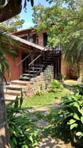 a house with a staircase in front of it at Pousada Raio de Sol Maresias in Maresias