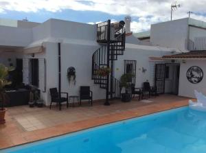 ein Haus mit einem Pool und einer Wendeltreppe in der Unterkunft Villa Bahamas private heated pool close to town. in San Bartolomé de Tirajana