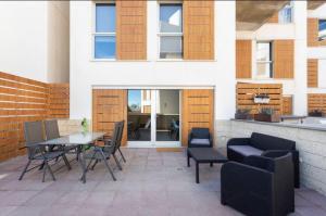 a patio with a table and chairs and a building at Modern seafront flat with a private garage in El Médano